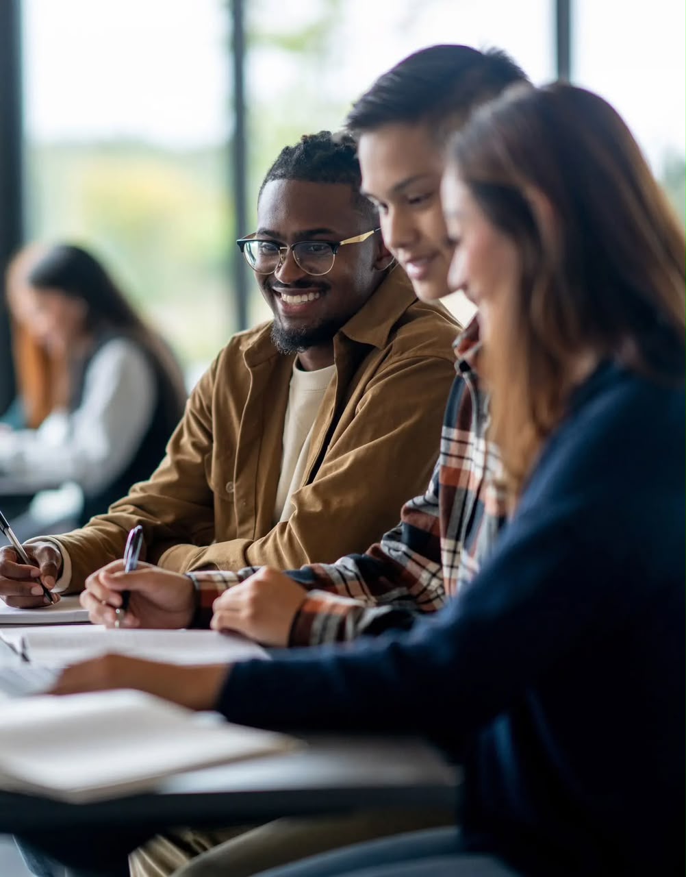 Étudiants attentifs en cours, en train de prendre des notes
